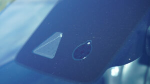 Close-up of a windshield-mounted camera housing behind the rearview mirror